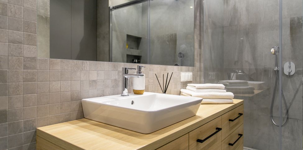 Jak urządzić małą łazienkę? Mała łazienka w bloku, duże lustro, kabina bez brodzika