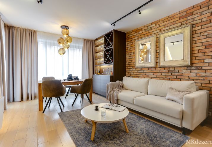 Lustra w ramach nad kanapą w salonie.