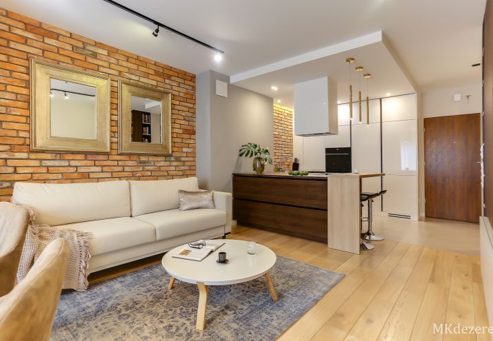 Projekt nowoczesnego mieszkania - głównym elementem w salonie jest zastosowanie czerwonej cegły rozbiórkowej połączonej z betonem.