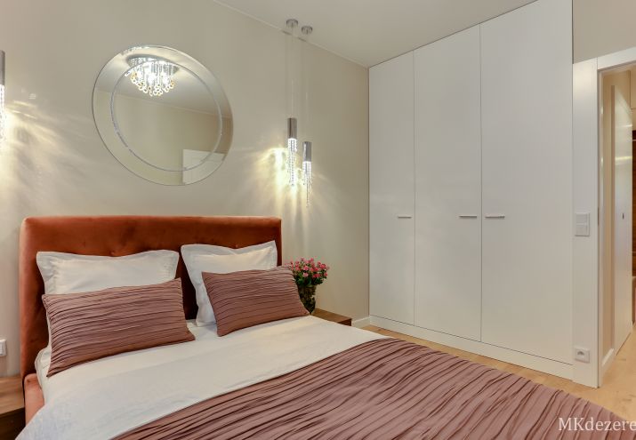 W sypialni oprócz łóżka z tapicerowanym zagłówkiem, znalazła się duża biała szafa.