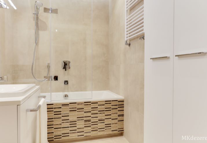 Aranżacja niewielkiej łazienki z pralką ukrytą w zabudowie.