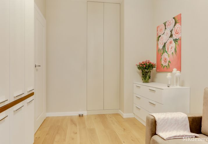 Białe meble w pokoju, białe drzwi i białe listwy przypodłogowe. Podłoga dębowa.