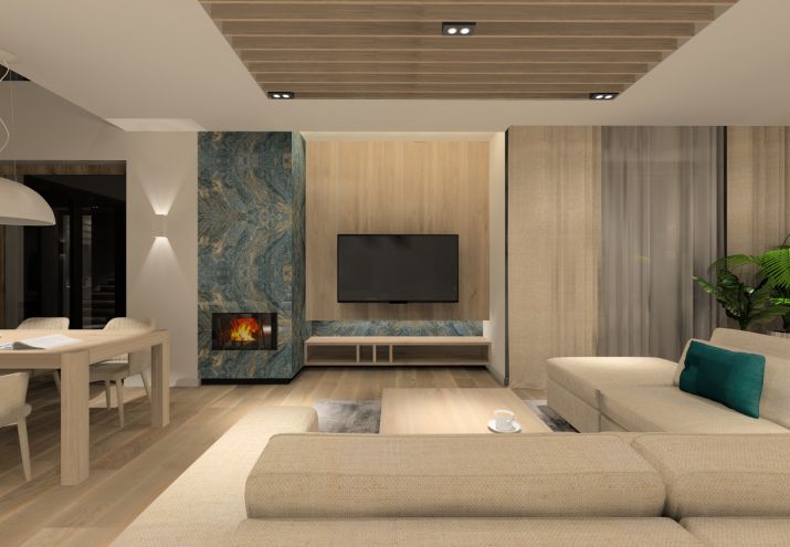 Duży, przytulny salon z kominkiem, akcentem kolorystycznym są płytki z dekorem kamiennym w kolorze niebiesko - zielonym. 