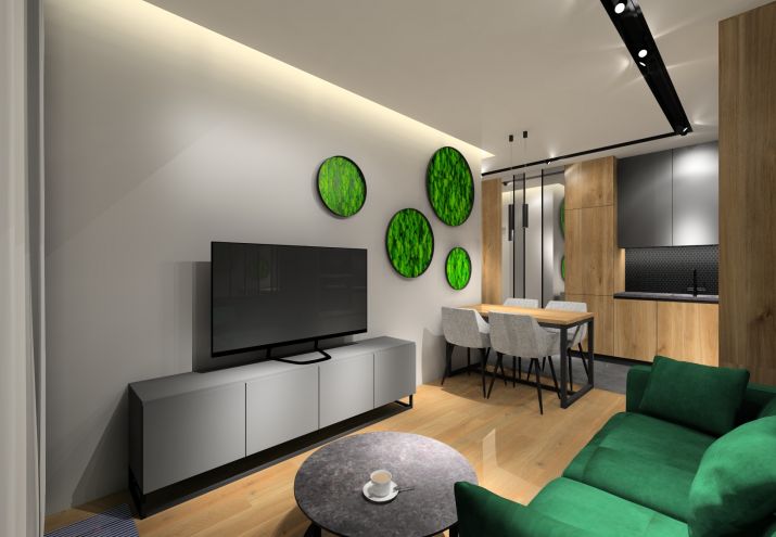 Aranżacja salonu z zieloną kanapą, na ścianie obrazy z mchu. 