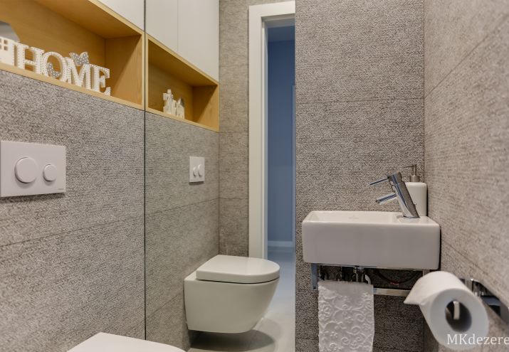 Aranżacja małej łazienki z wc w szarościach.