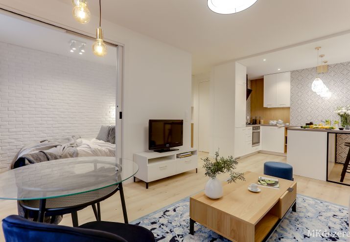 Sypialnię od salonu oddzielają wysokie chowane w ścianie podwójne drzwi.