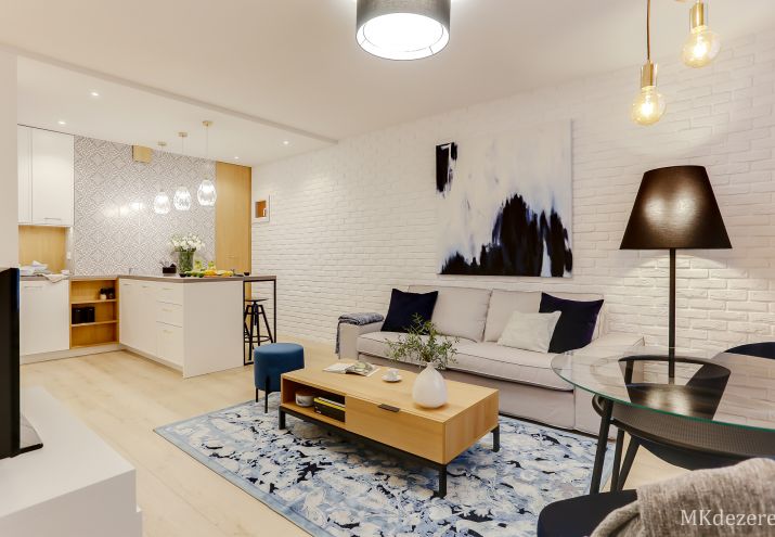 W niewielkim mieszkaniu, głównym elementem dekoracyjnym jest biała cegła umieszczona na najdłuższej ze ścian.
