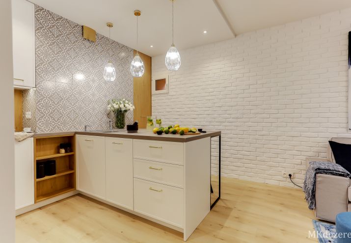 Projekt białej kuchni ze złotymi uchwytami.