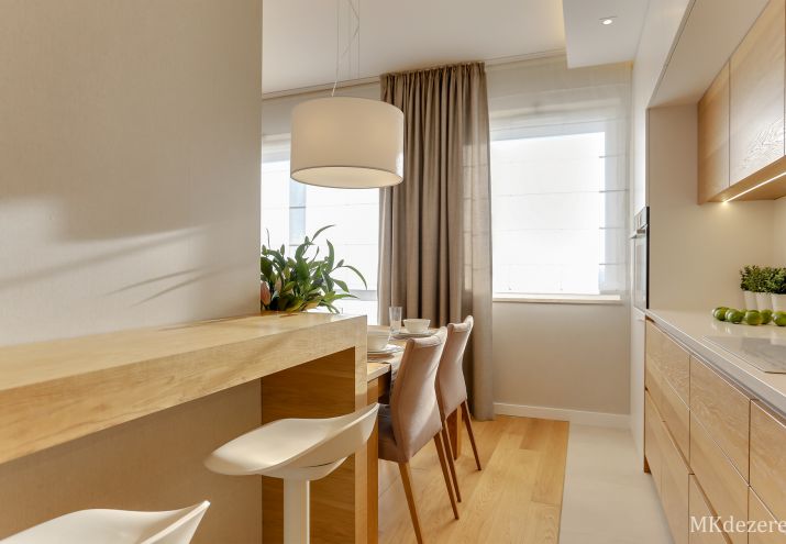 Białe rolety rzymskie połączone z zasłonami.