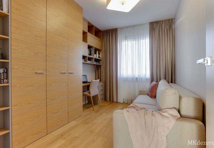 Projekt pokoju pełniącego funkcję domowego biura. Jedną ze ścian zajmuje zabudowa meblowa połączona z biurkiem.