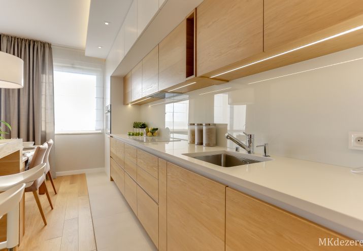 Biała lakierowana kuchnia połączona z ciepłym drewnem.