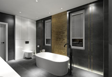 Łazienka z wanną wolnostojącą z hydromasażem. Czarne płytki zostały połączone ze złotem i bielą.